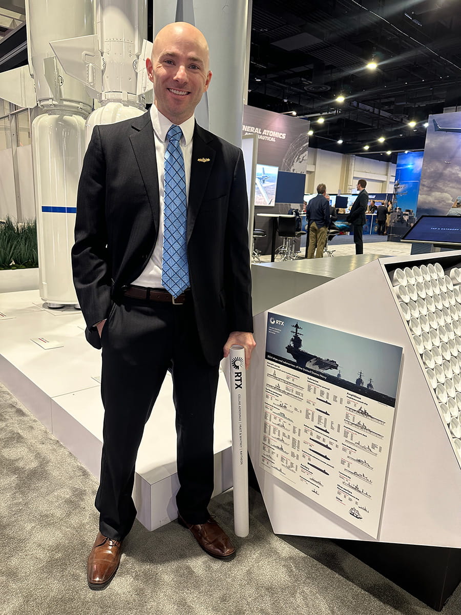 Cory Lloyd with poster inventory at tradeshow floor