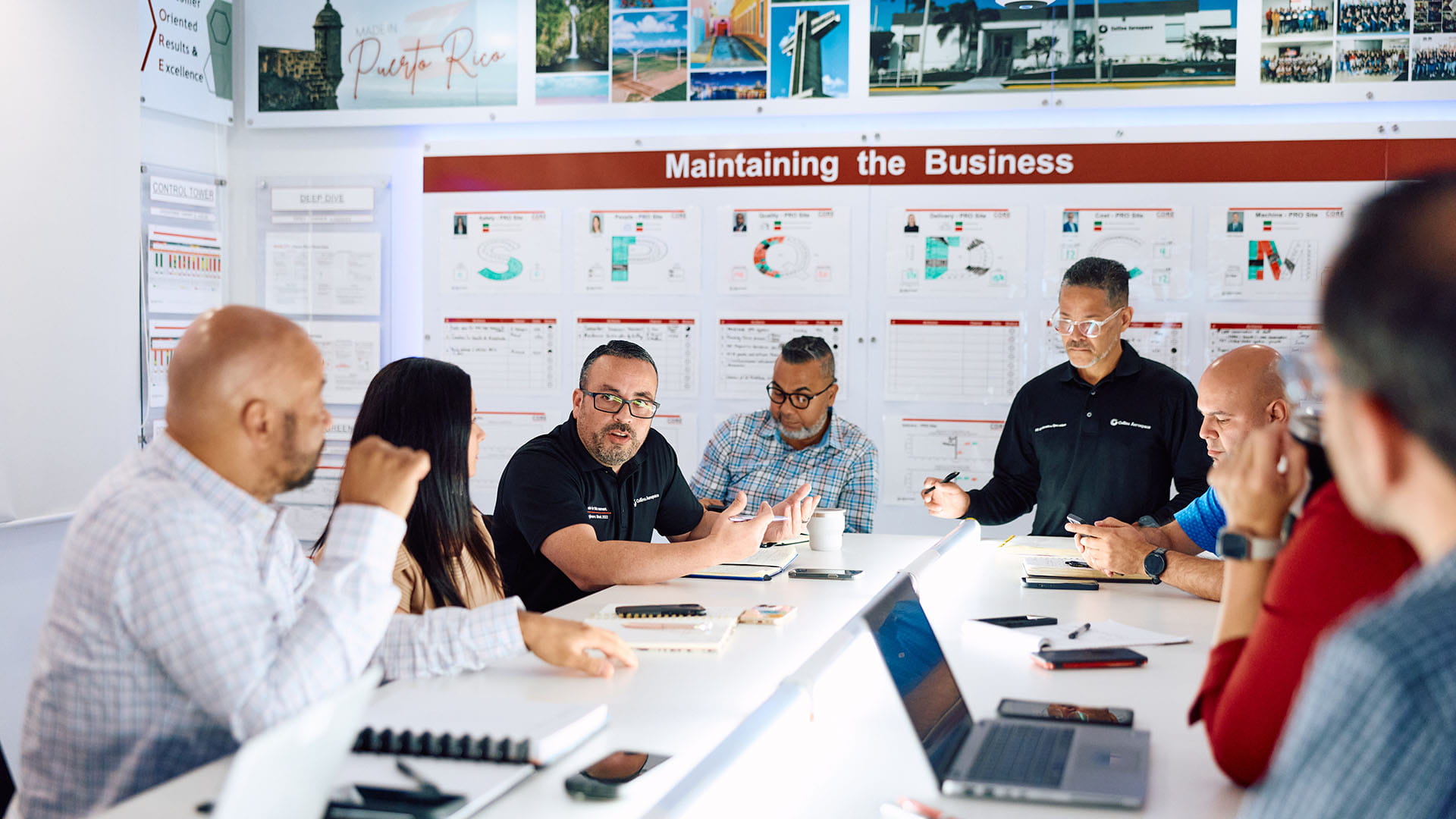 a group of RTX employees around a conference table in a discussion.