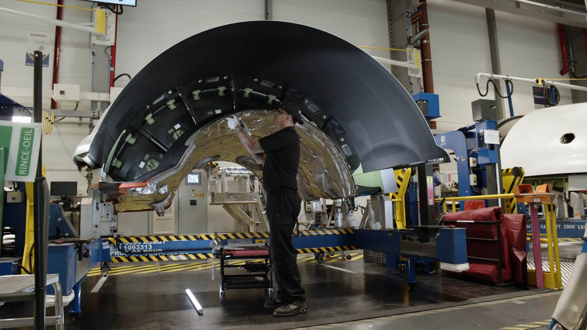 a maintenance technician working  on part of a nacelle in the shop