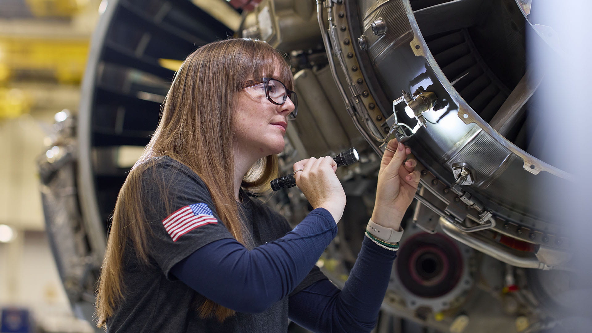 A technician at Pratt & Whitney’s West Palm Beach Engine Center performs a maintenance check on a PW1100G-JM GTF engine