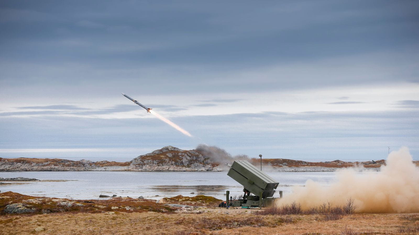 A surface to air missile firing next to a body of water