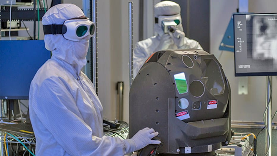Engineers at Raytheon Intelligence & Space’s high-energy laser lab in McKinney, Texas, analyze a beam director.