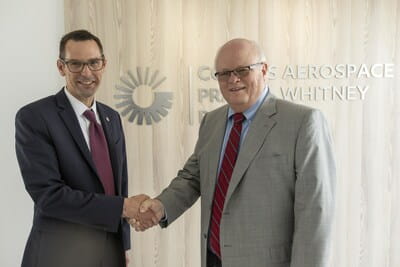 Collins Aerospace vice president of Aftermarket for Power & Controls Ryan Hudson shakes hands with Envoy Air senior vice president for Corporate Services John Nicks.