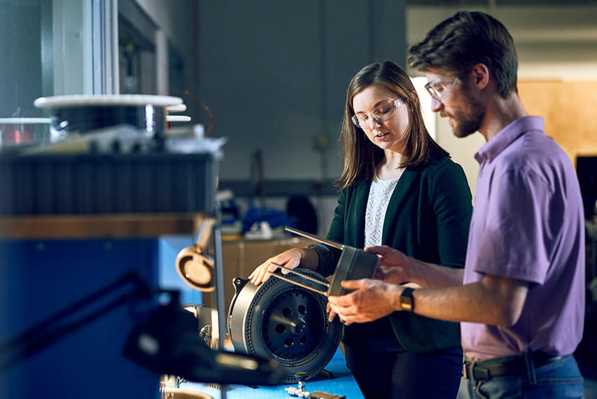 Two workers looking over a piece of machinery