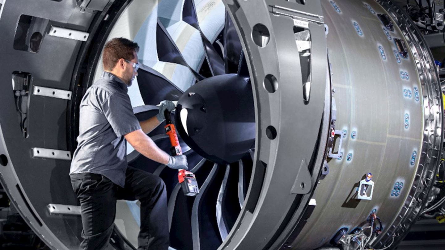 airplane mechanic next to a Pratt & Whitney engine