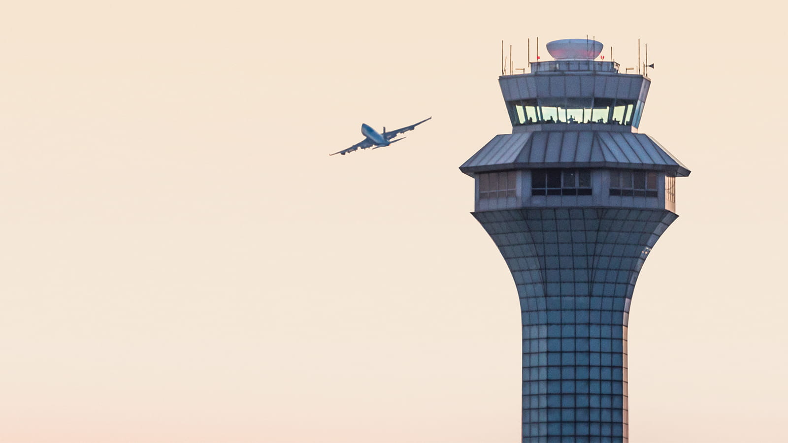 Airplane flying next to air traffic control tower