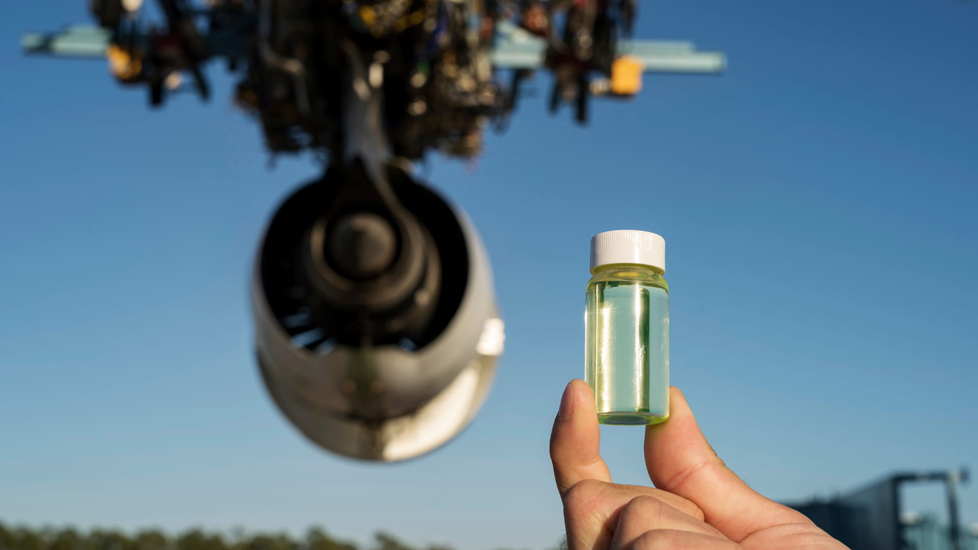 Hand holding a vial containing an alternate aviation fuel source