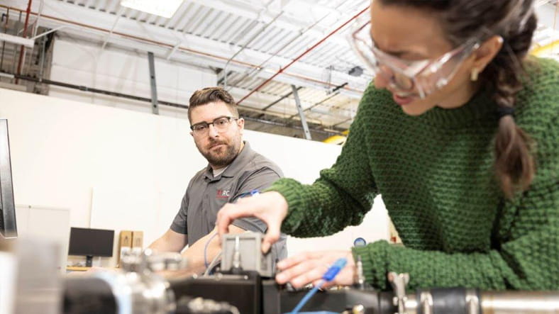 Two workers working on a piece of machinery