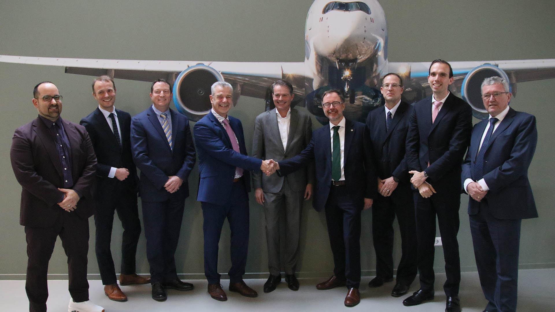 a group of businessmen in front of an aircraft