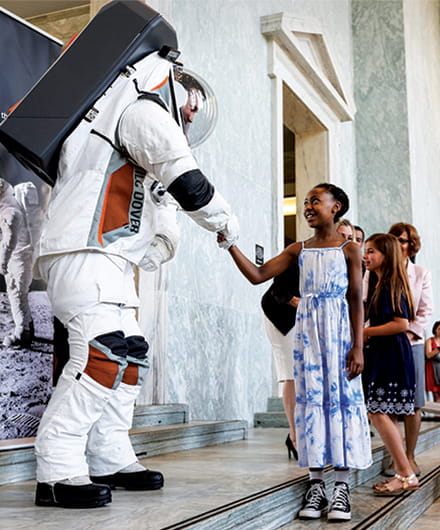 Children are waiting in line to shake hands with an astronaut