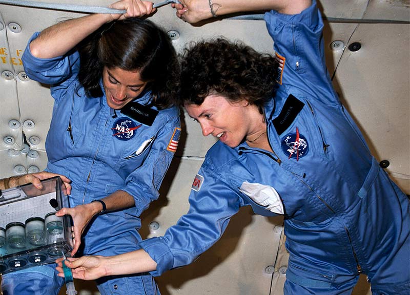 Christa McAuliffe working with a female colleague on a science demonstration for her Teacher in Space mission