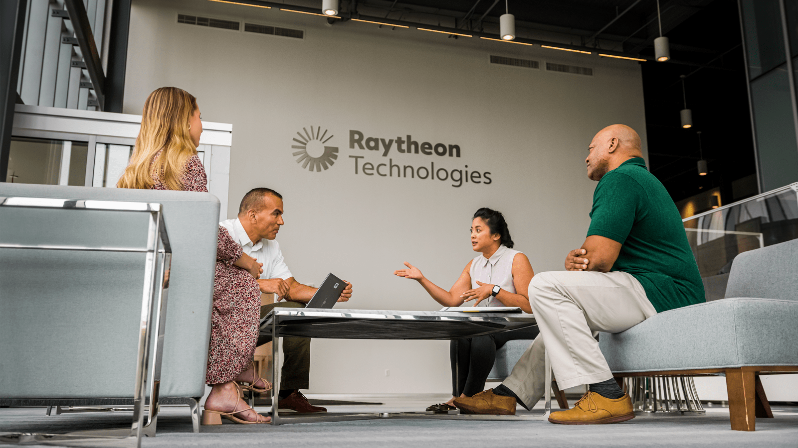 A group of employees having a conversation around a table 