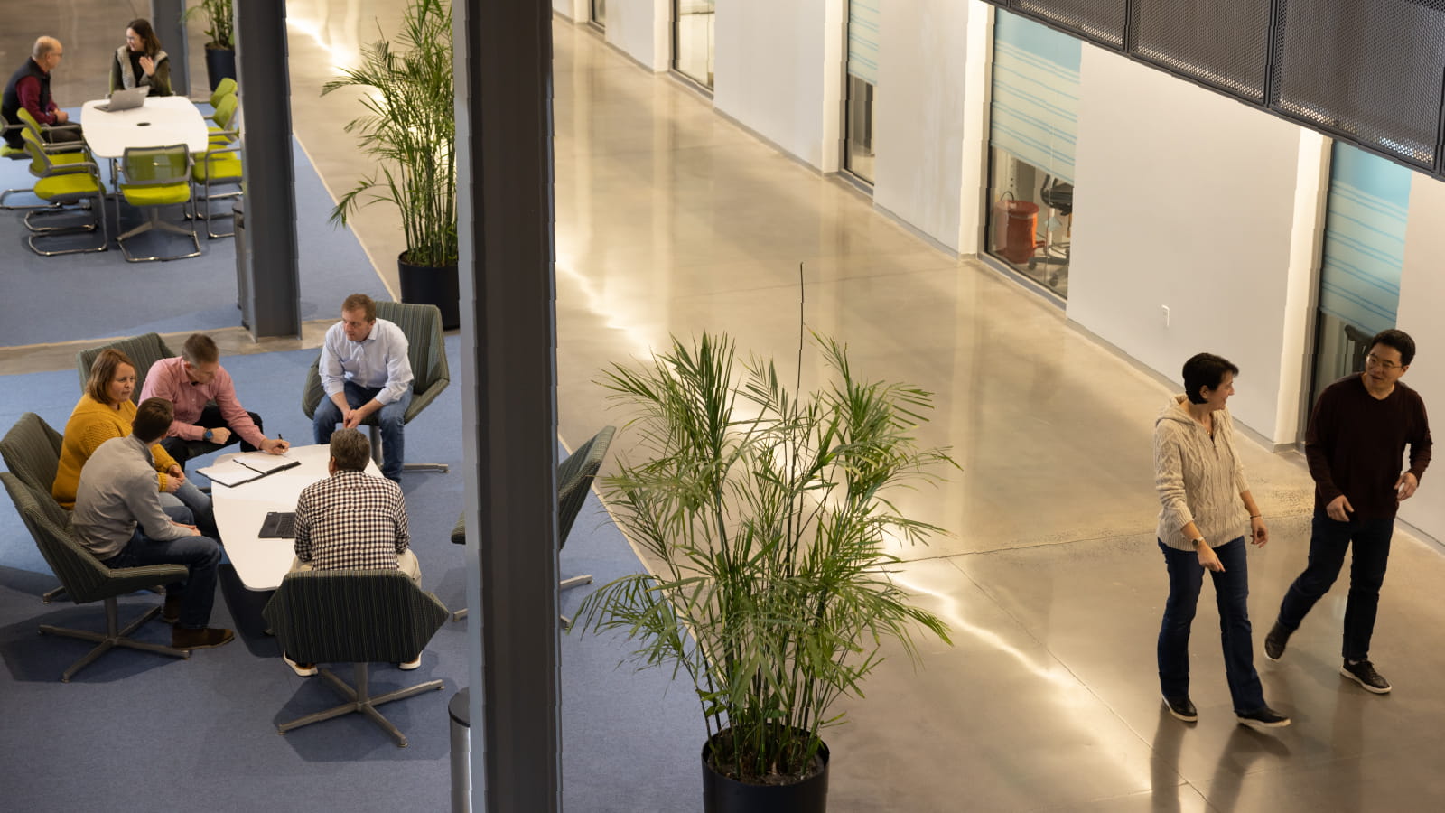 Aerial view of office lobby with employees sitting at tables and walking