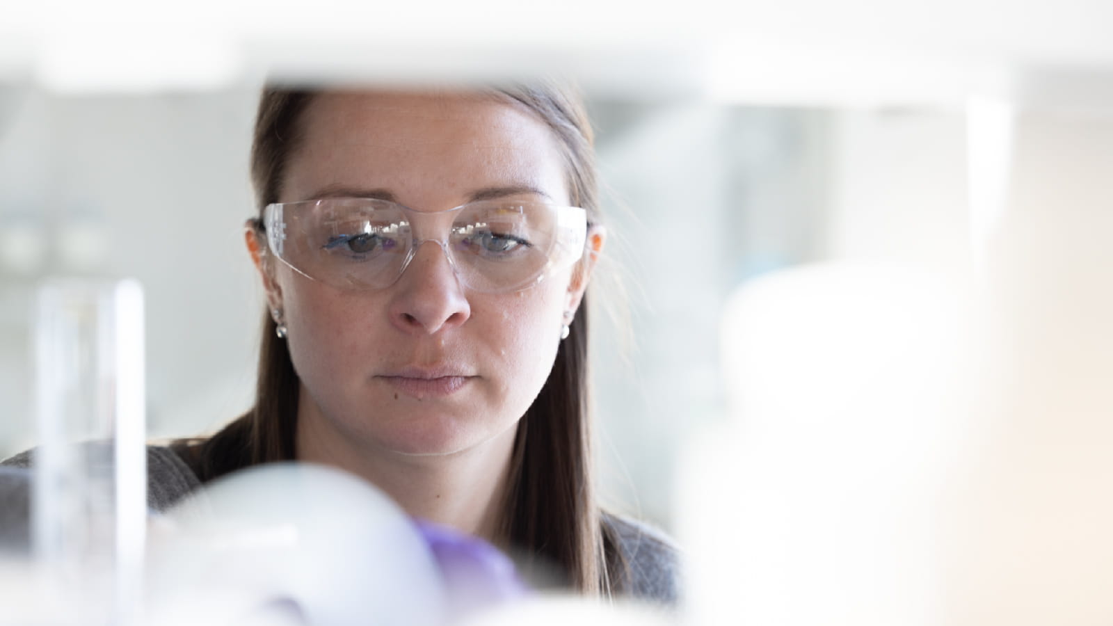 Close-up of woman in lab wearing protective eyegear