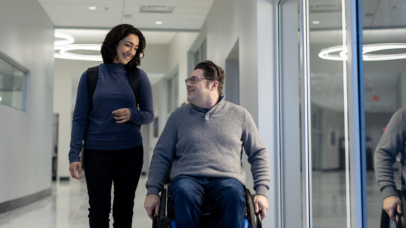 Woman and man in wheelchair in a hallway