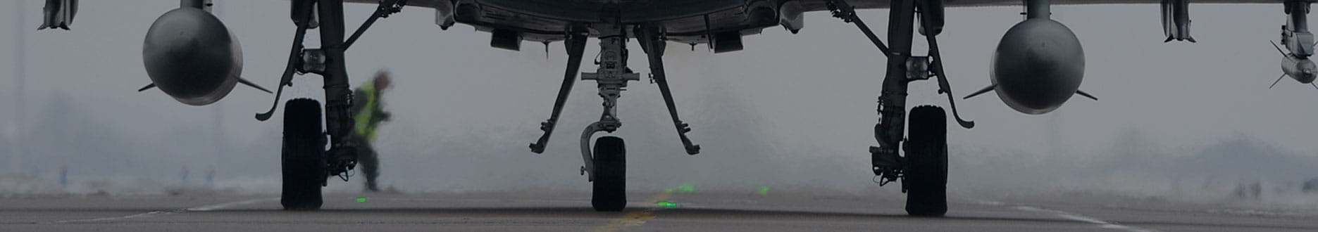 zoom on military aircraft landing gear on tarmac