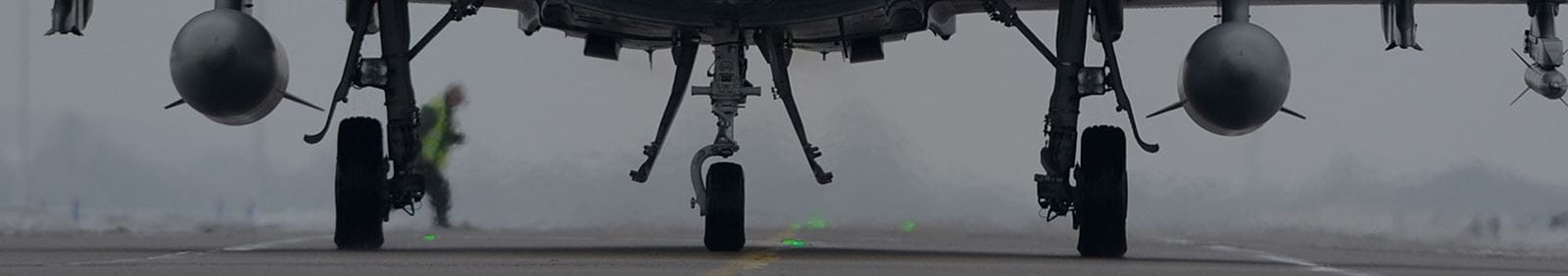 zoom on military aircraft landing gear on tarmac