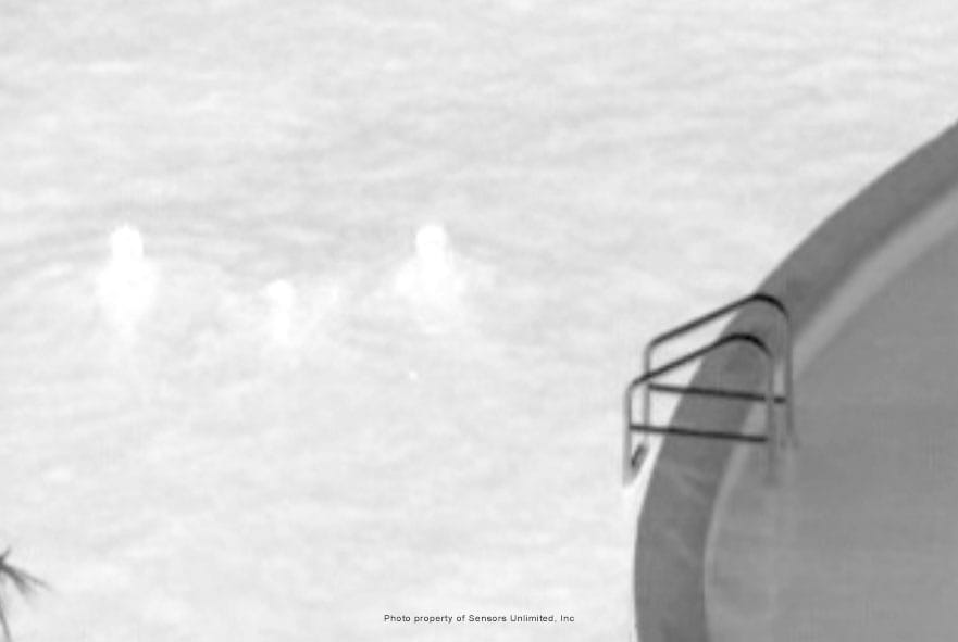 Three people in a swimming pool viewed with a thermal imaging camera