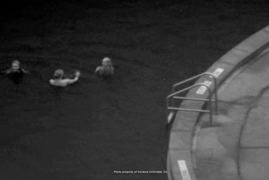 Three people in a swimming pool viewed with an infrared camera