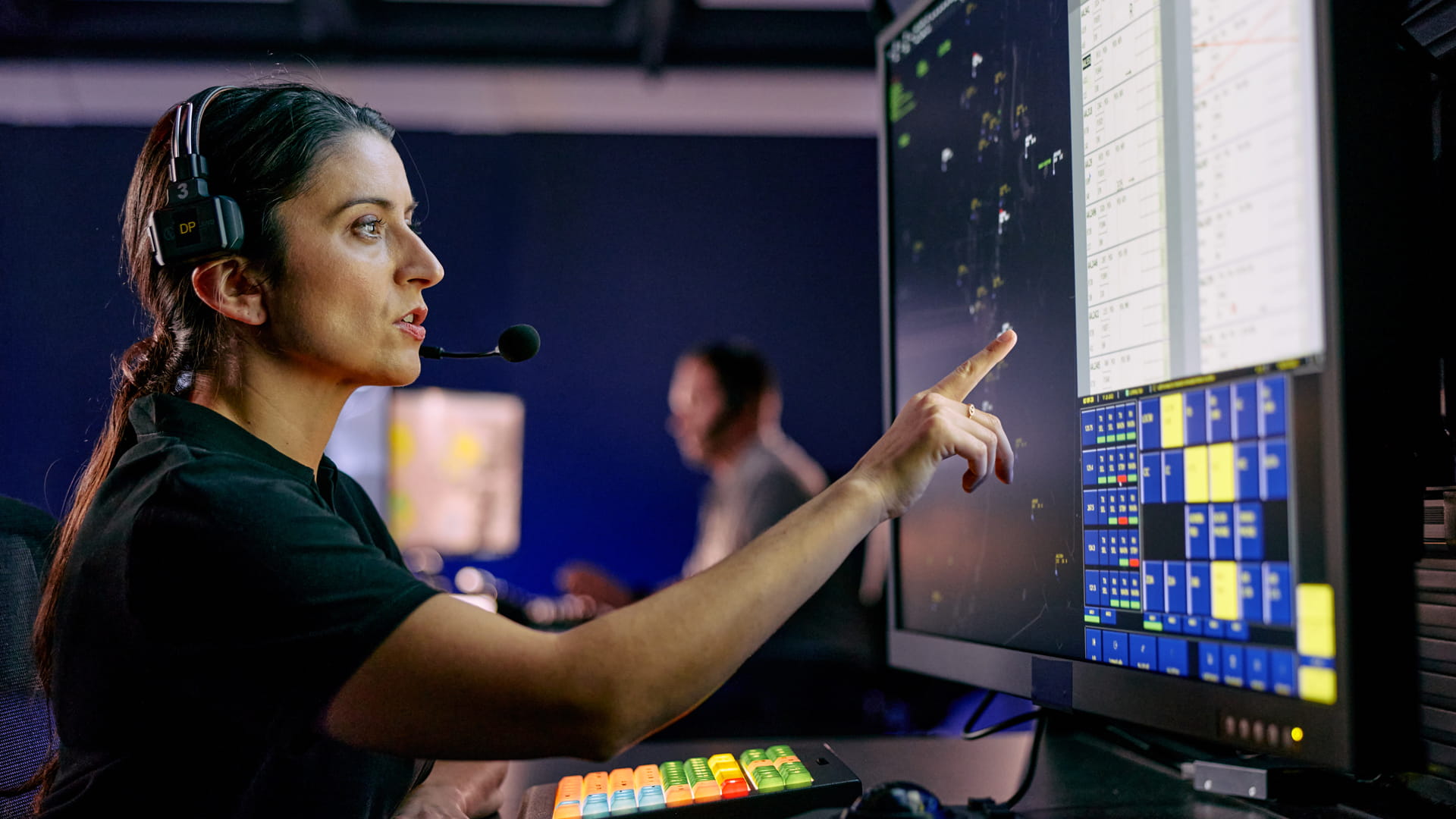 Air traffic controller working in front of several large screens