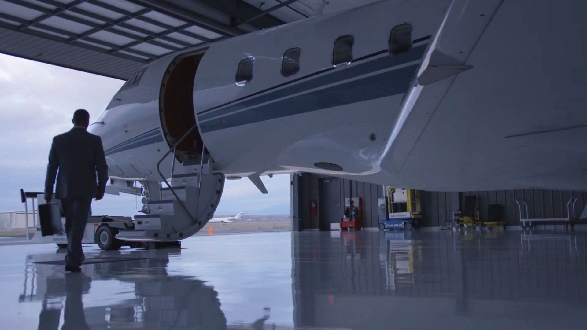 A man with a briefcase walking up to a business jet
