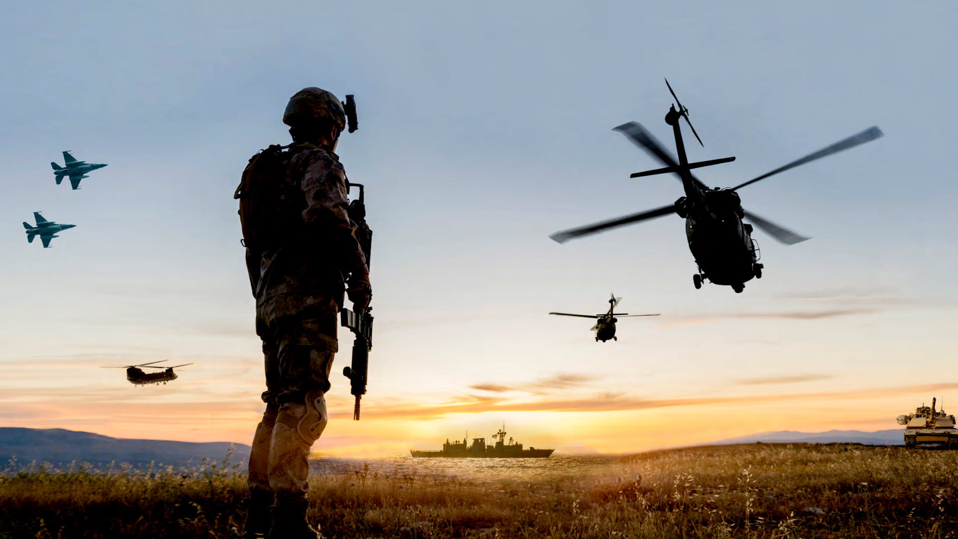 A soldier in silhouette stands looking out at three helicopters, two fighter jets, a tank and a battleship