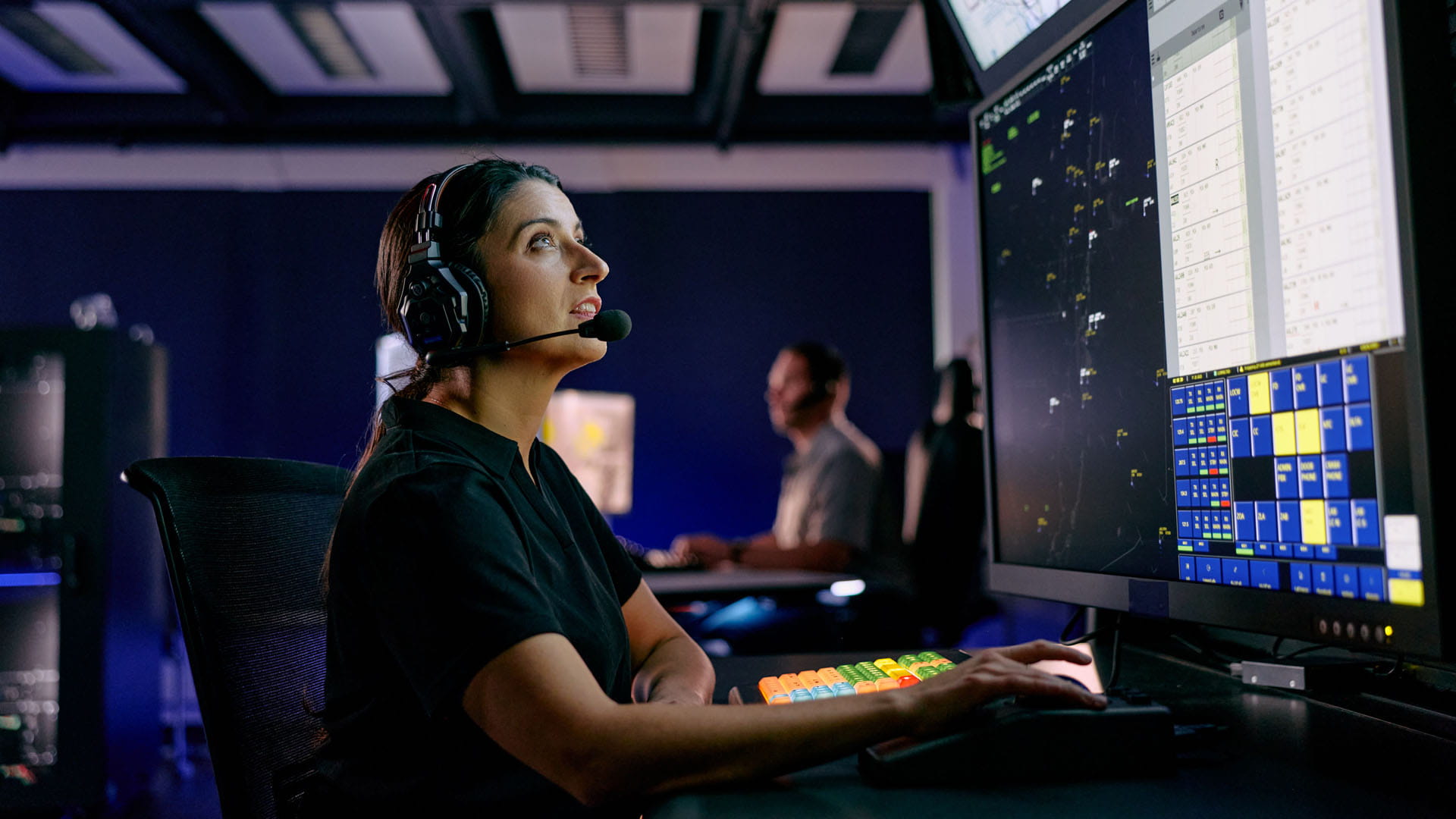 Air traffic controller working in front of several large screens