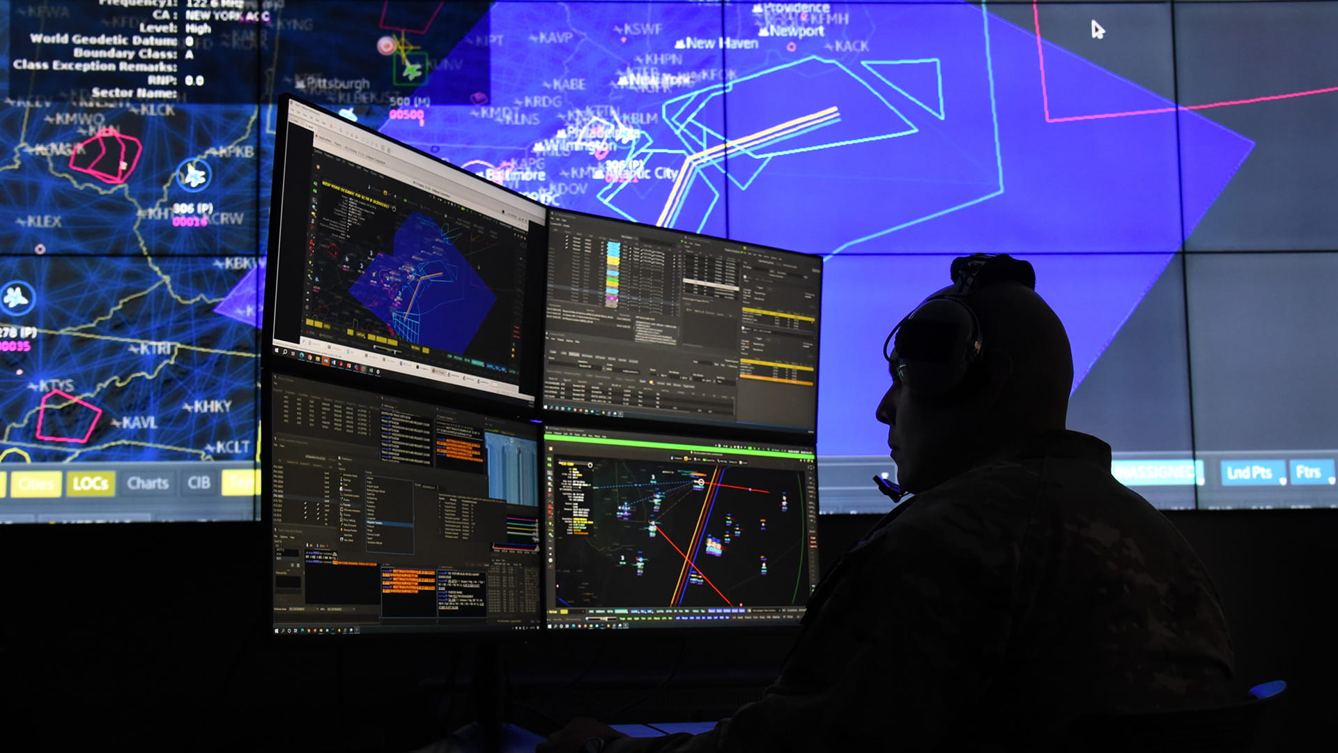 Operators viewing multiple monitors in a military command center