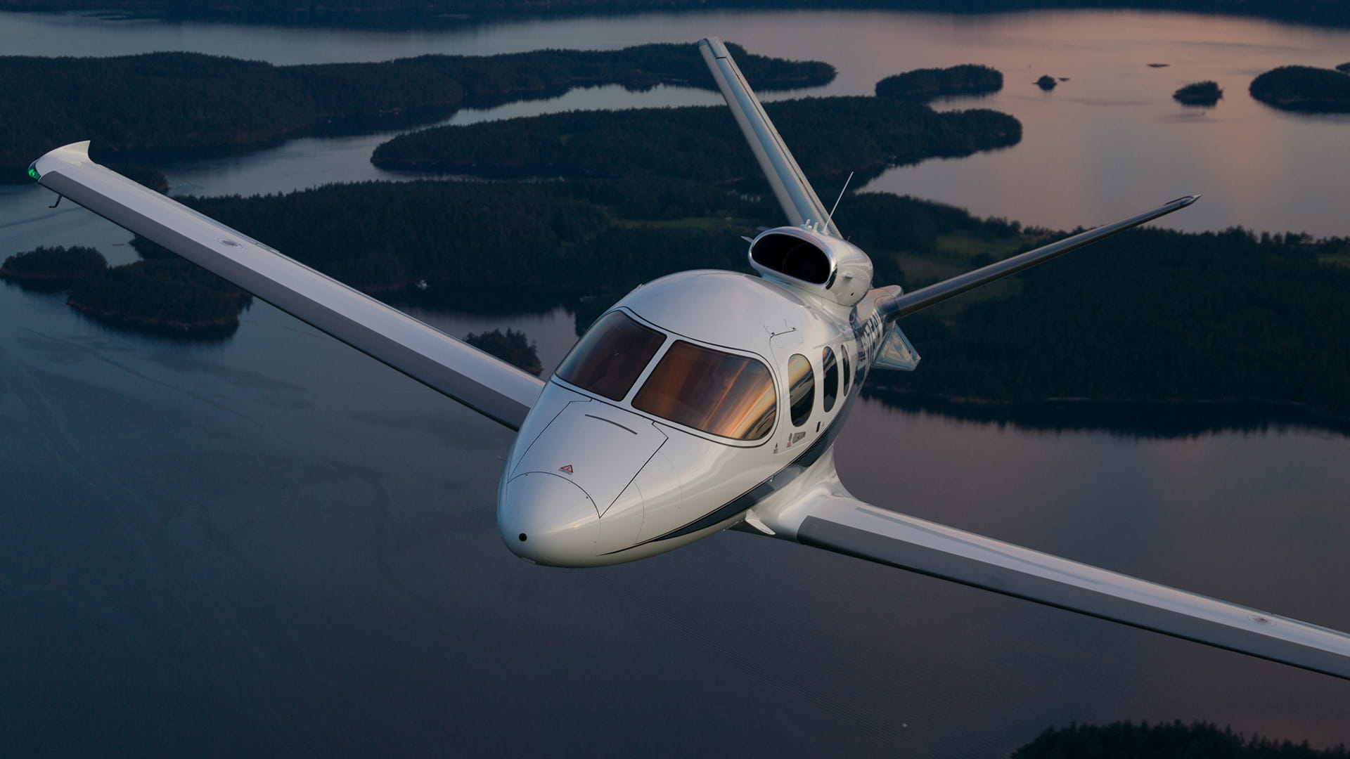 Cirrus Vision G2+ aircraft in flight over a body of water