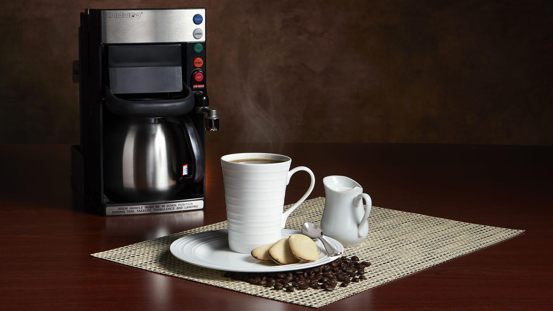 Endura Beverage Maker pictured behind a coffee cup and plate