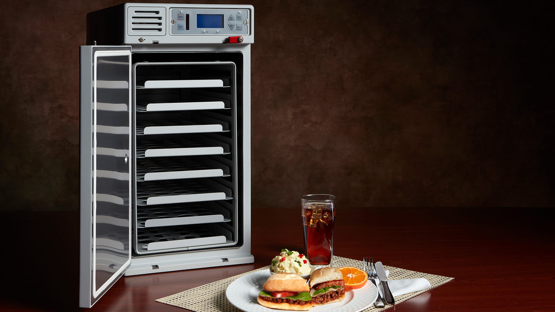 Endura Convection Oven pictured with a plate of food and a glass filled with liquid