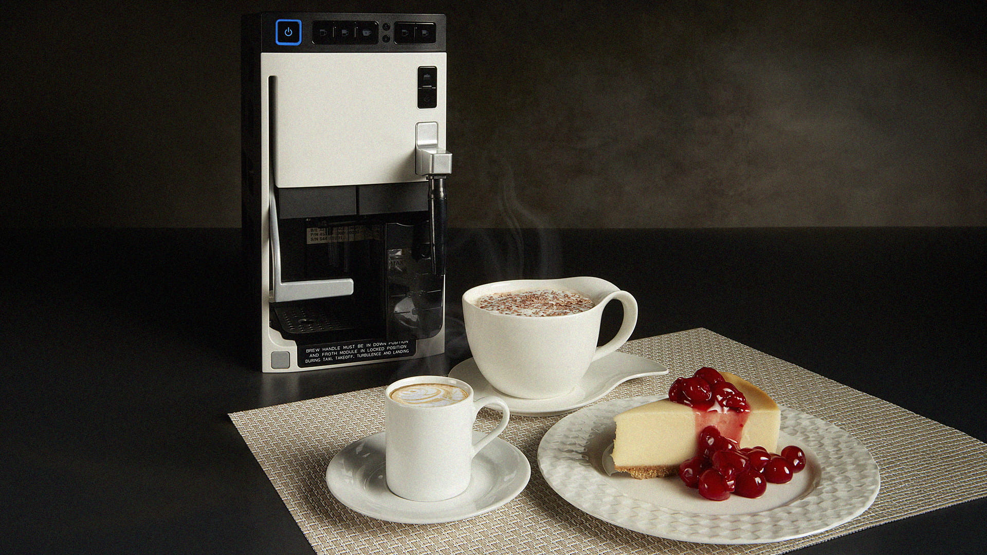 An espresso machine, two beverage cups, and a slice of cheesecake on a dessert plate