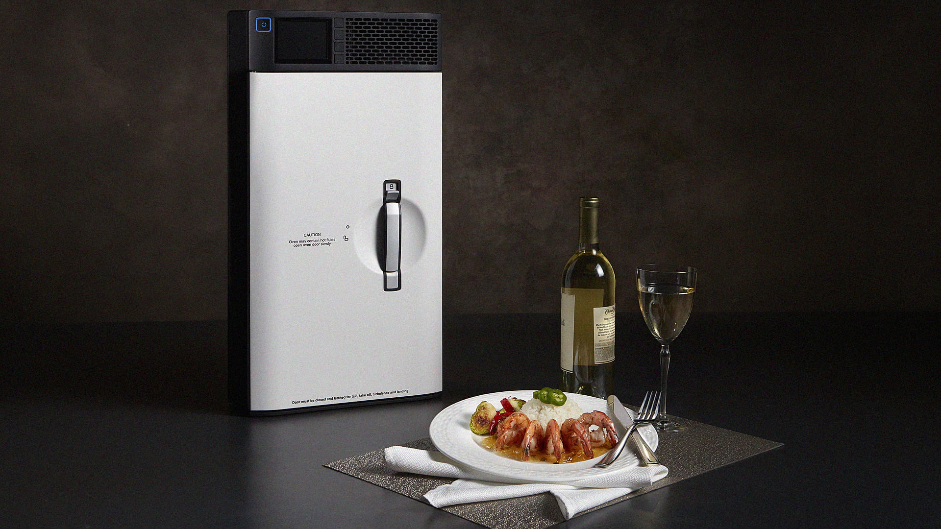 A convection oven, a plate of food, a bottle of wine and a wine glass