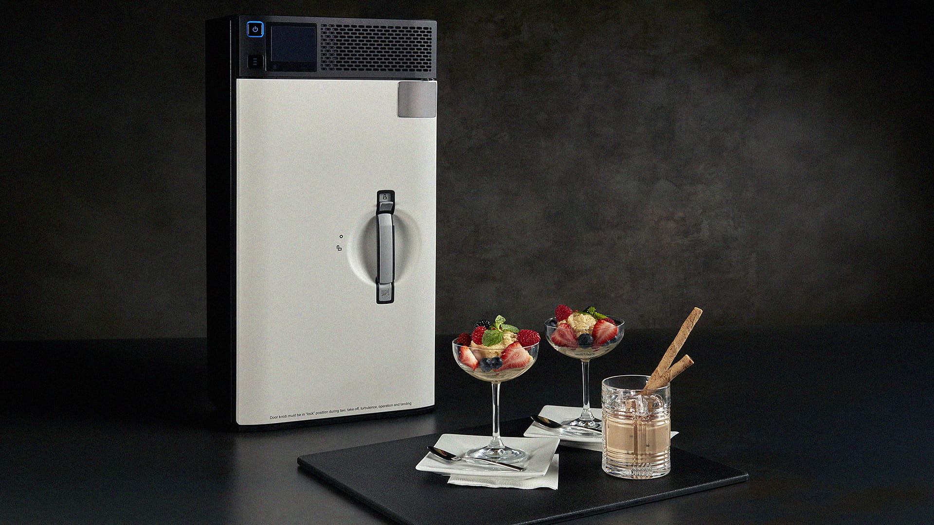 A beverage chiller, two dessert cups, and a cup of liquid