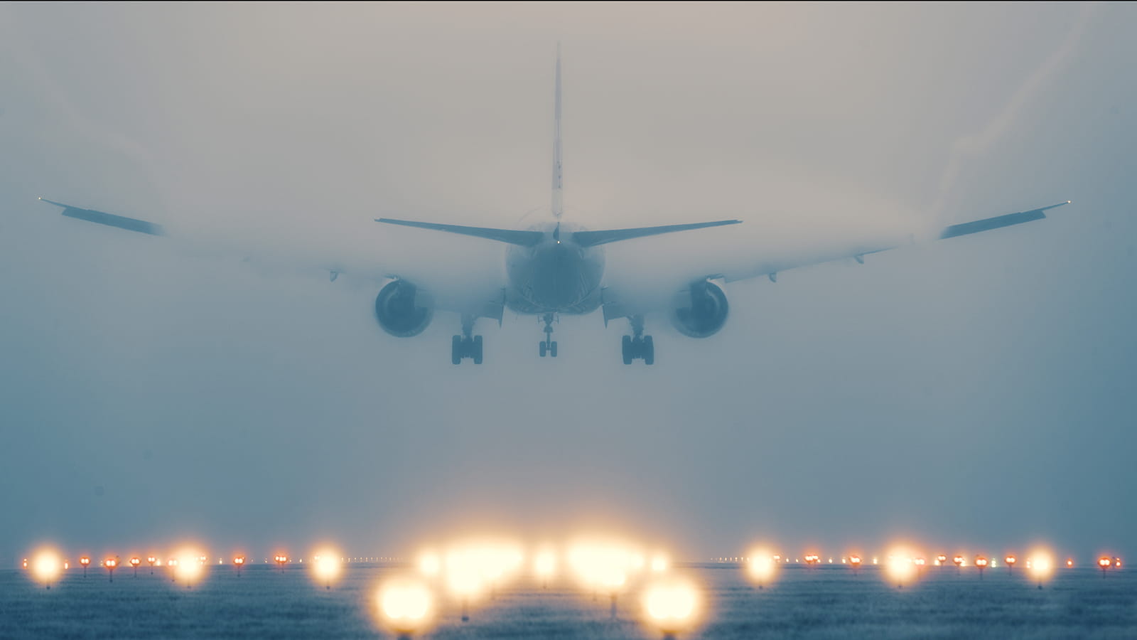 An aircraft landing on a lit runway