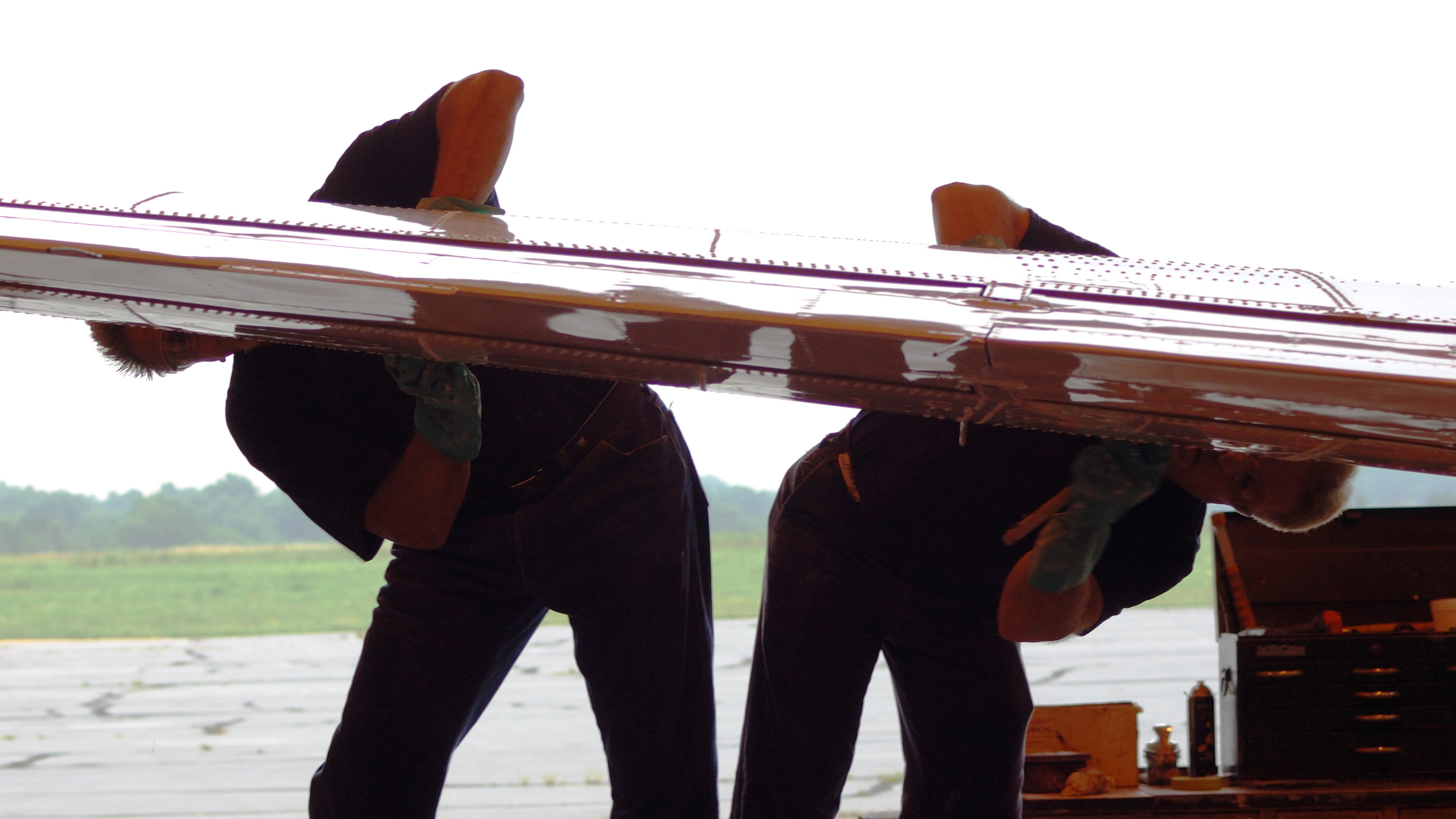 Technicians working on an aircraft wing de-icer