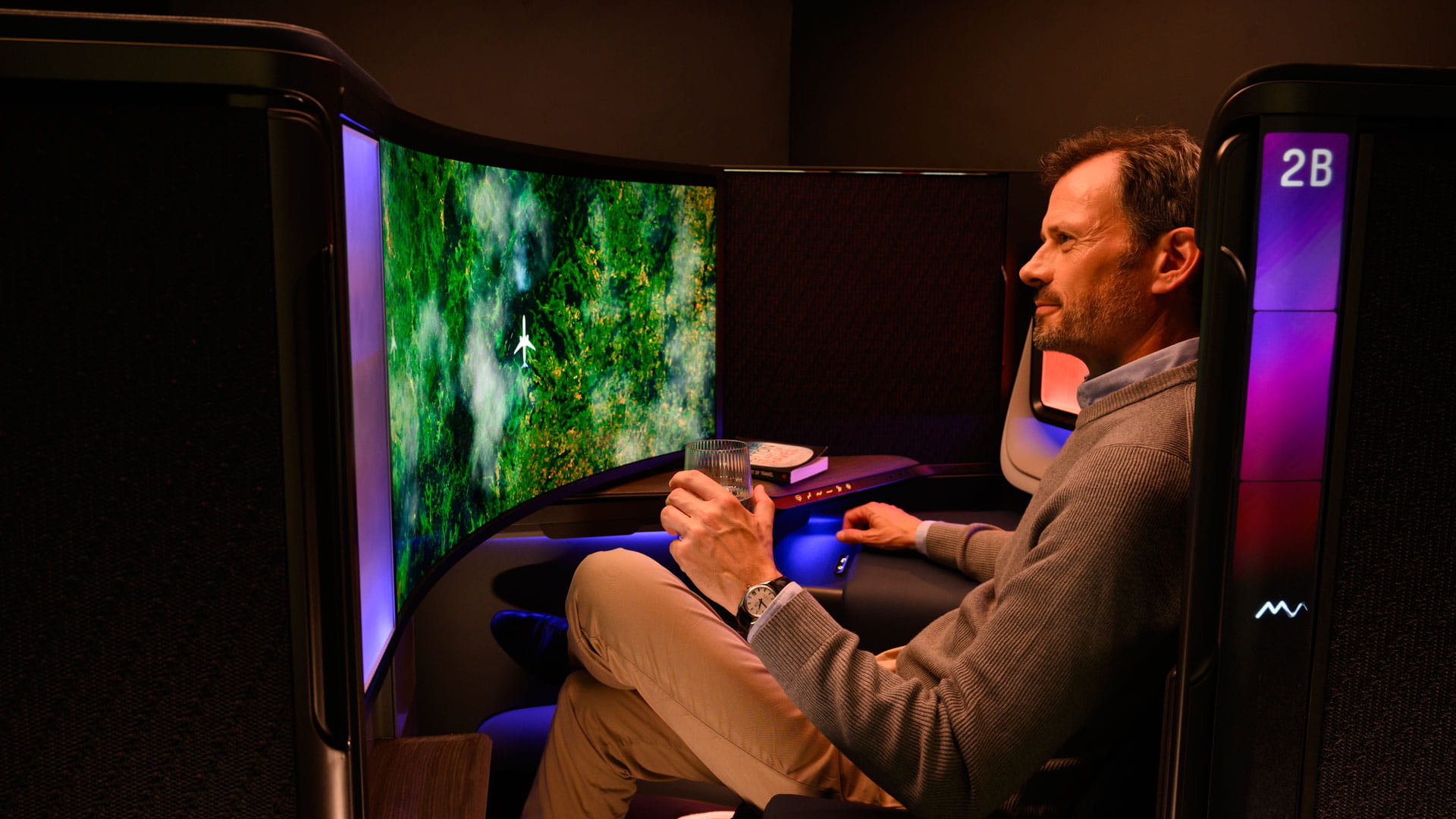 A man watching TV in a luxury business aircraft suite