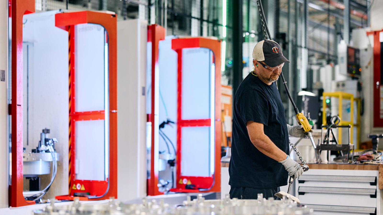 A Collins Aerospace operator works in a next-gen wheel machining cell, which has two advanced machines that take up a fraction of the space of the legacy equipment.