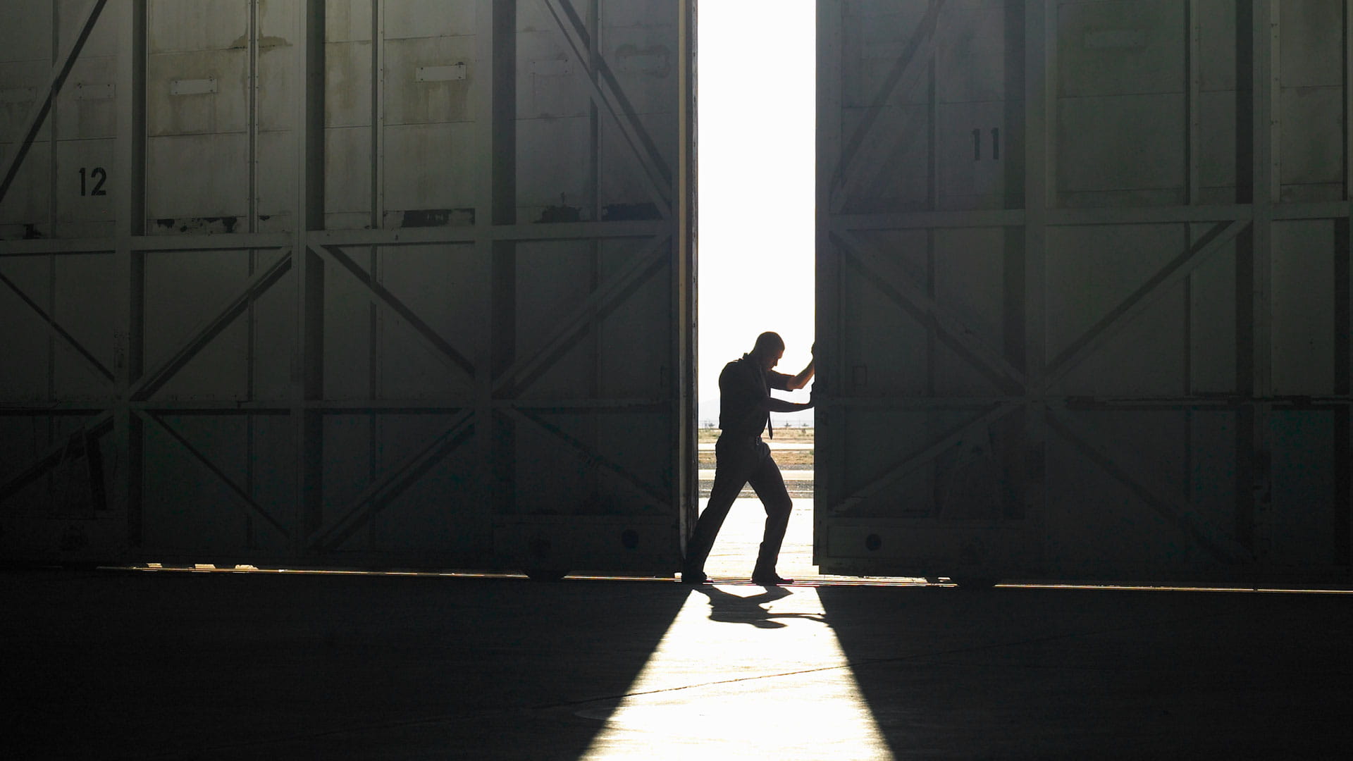 Man opening hangar door