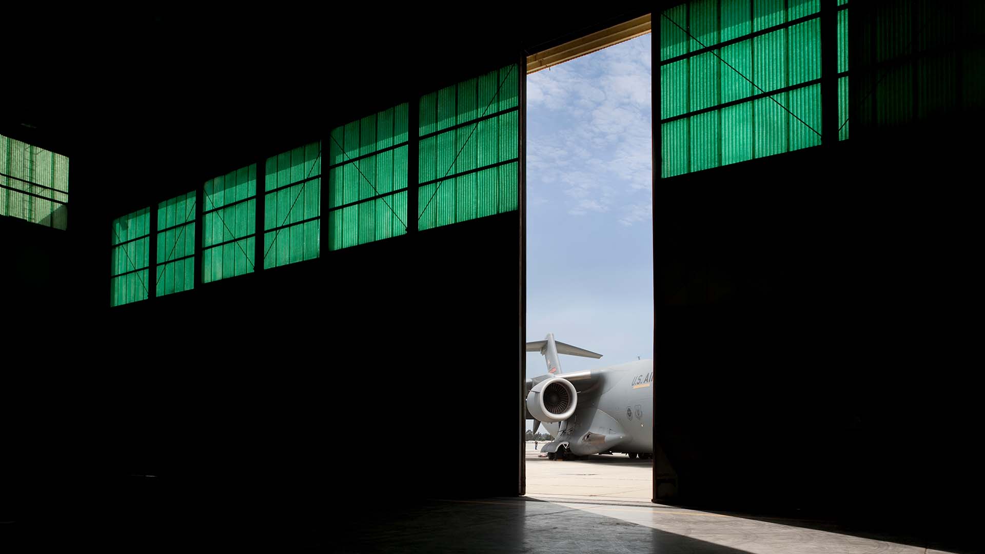 black and white military aircraft hangar with engine showing