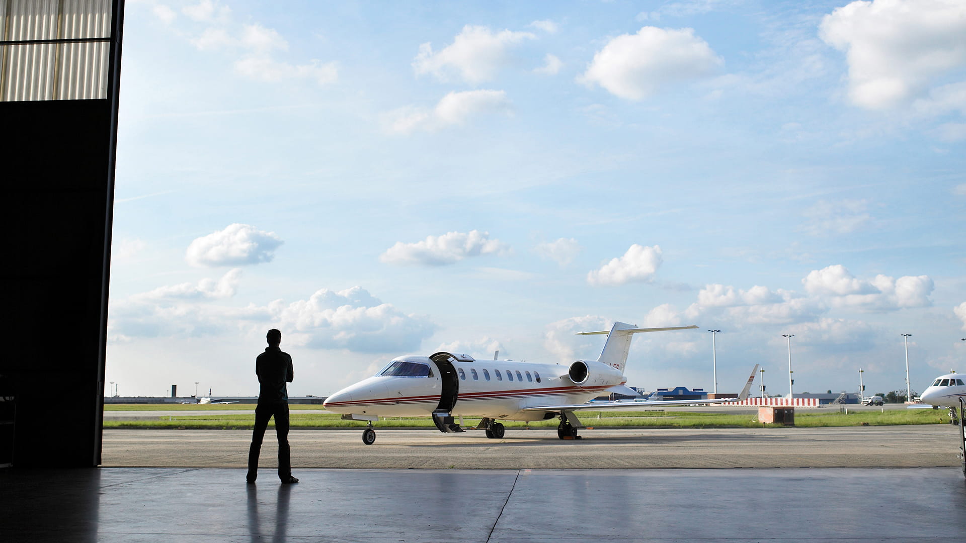 Business jet sitting outside hangar