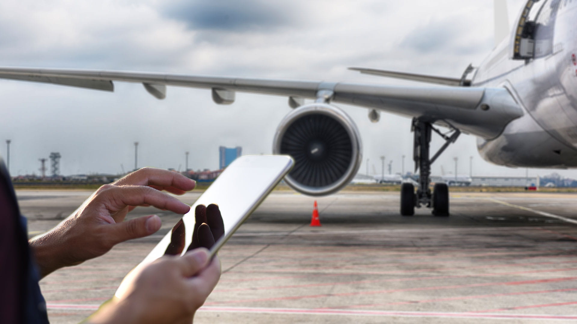 A person interacts with a touch device while standing in front of an aircraft