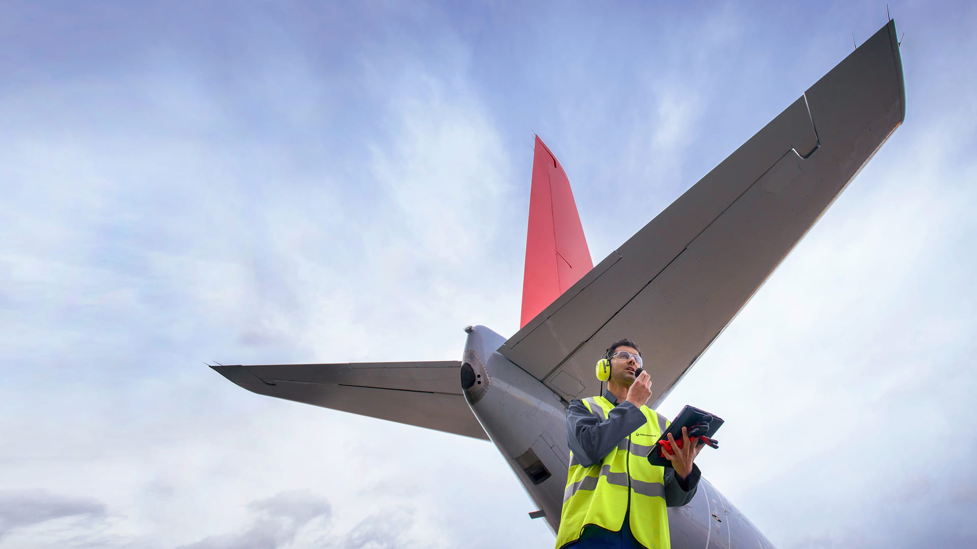 Ground controller next to tail of plane
