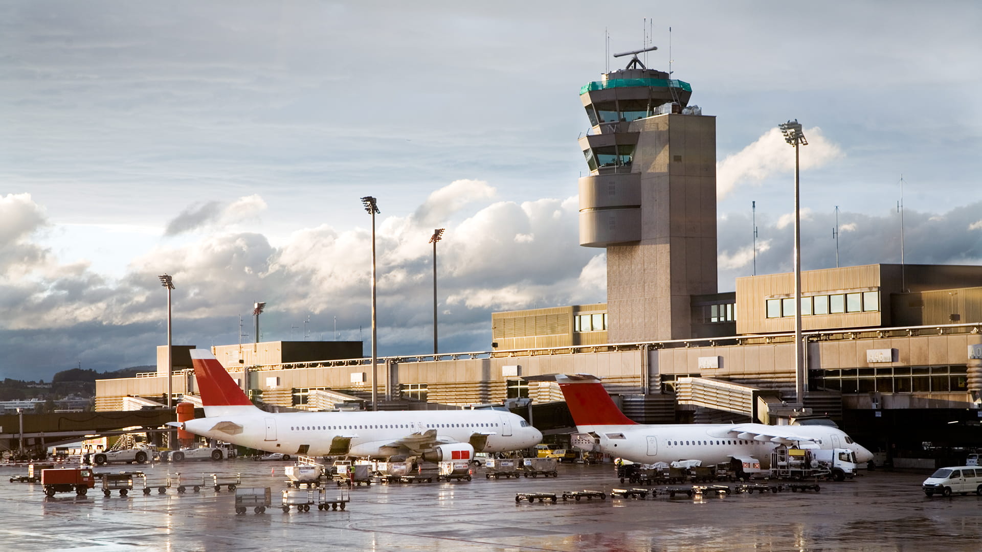 Two aircraft parked at airport jet bridges