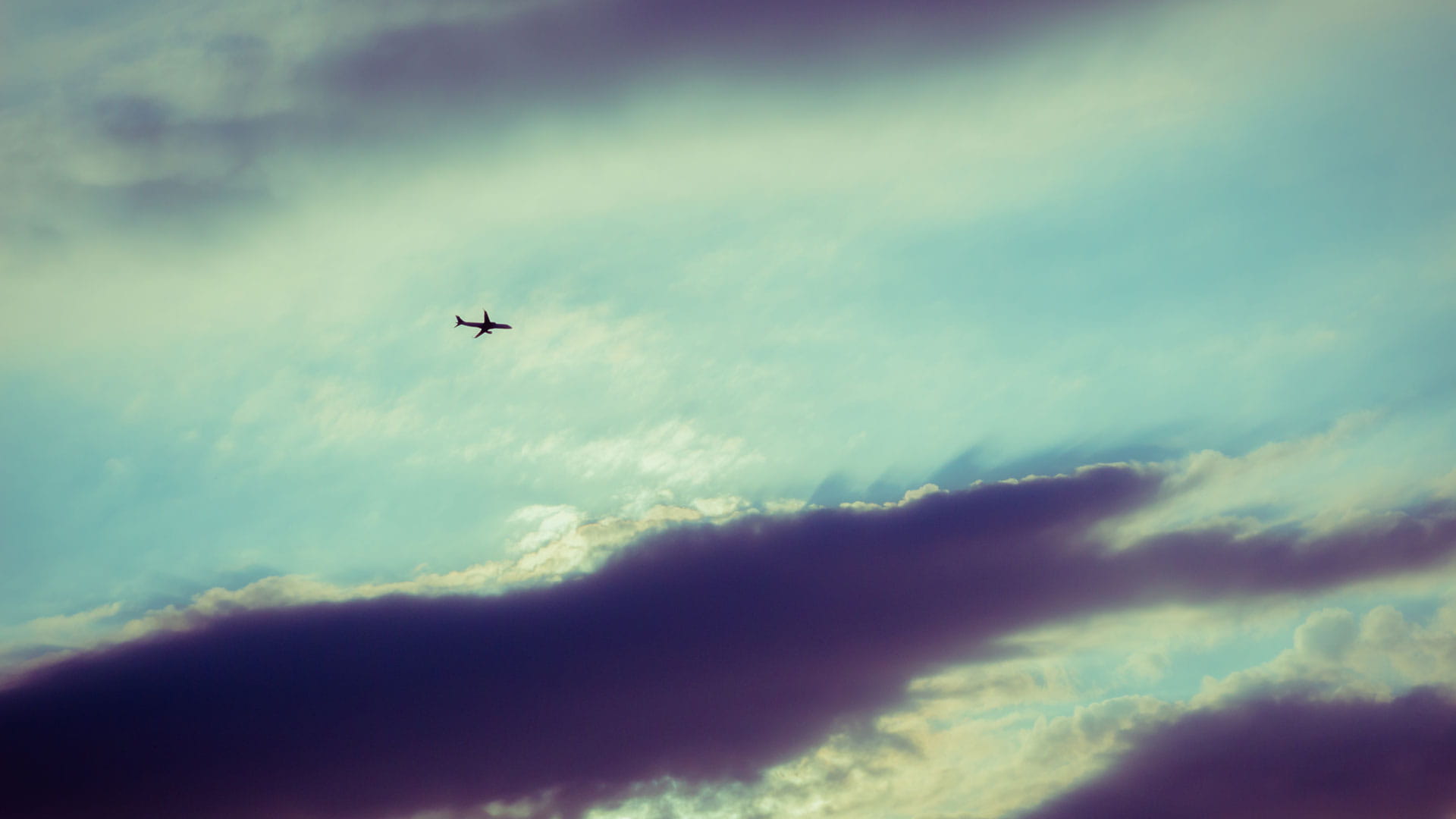 Silhouette of an airplane flying in sunset sky