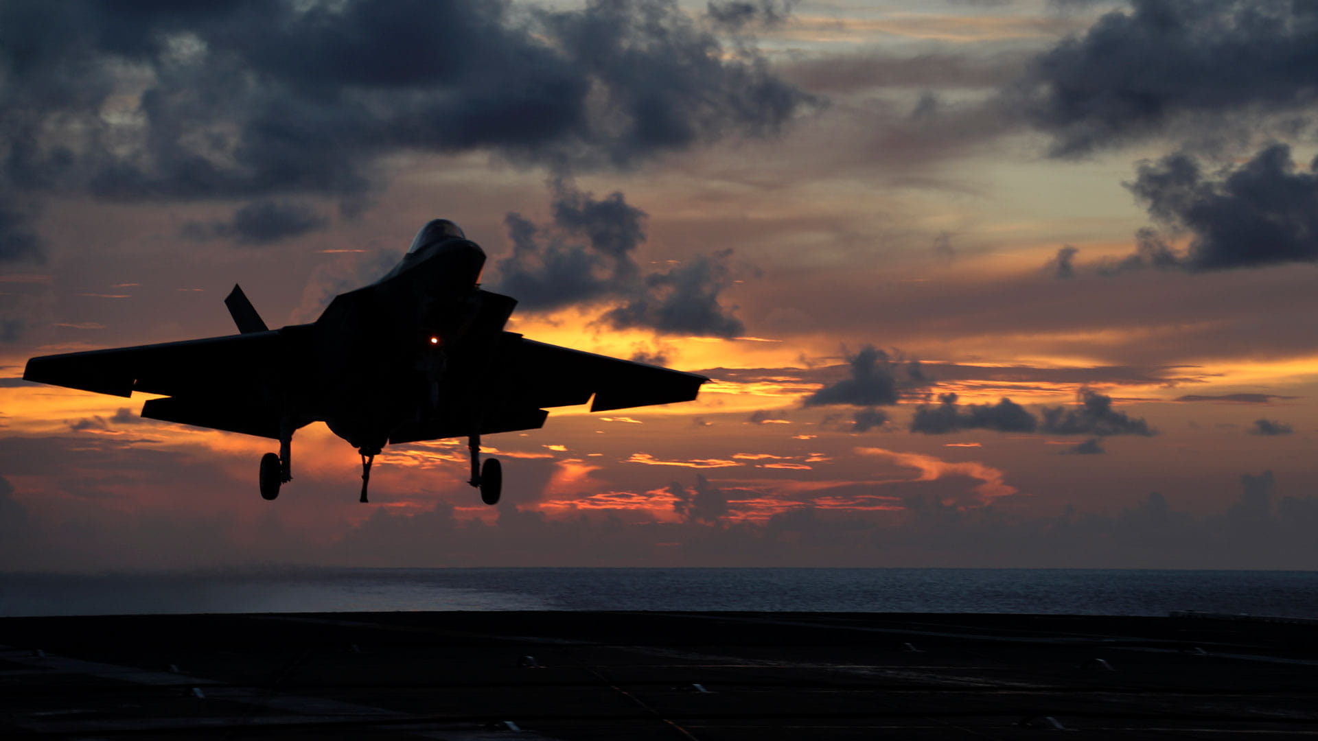 An F-35 flight approach (prior to trapping) during sunset. Photo by Jeffrey M Sherman