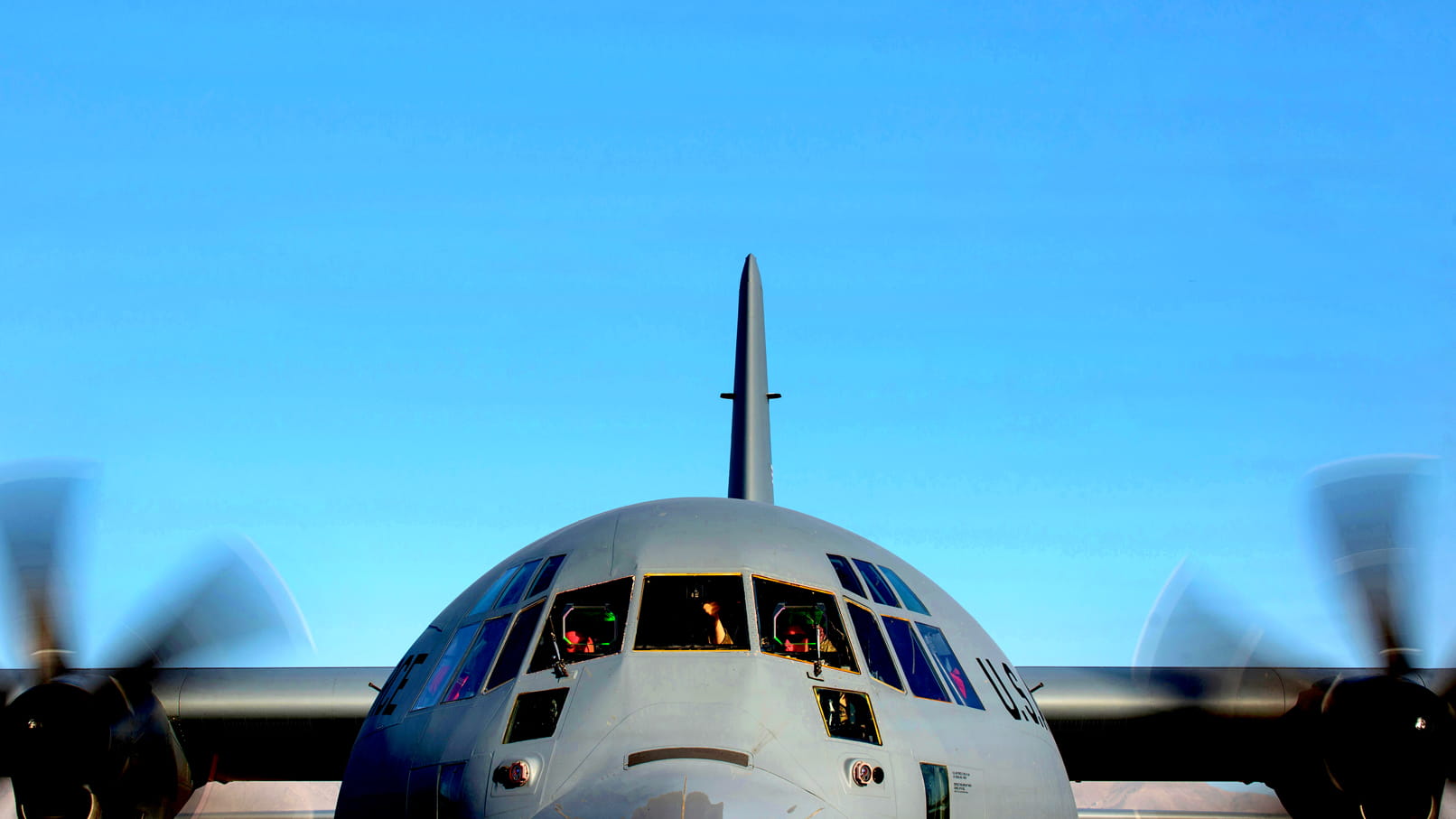 Military C-130 plane with props spinning