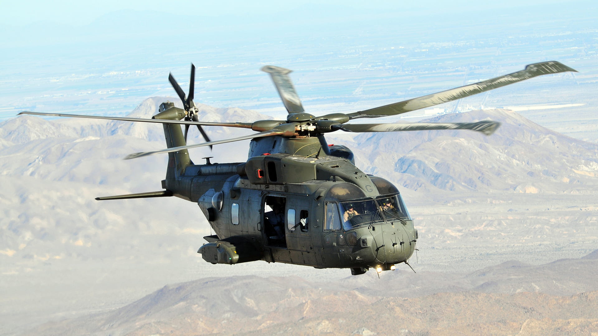 Aerial photo of a military helo with side bay doors open