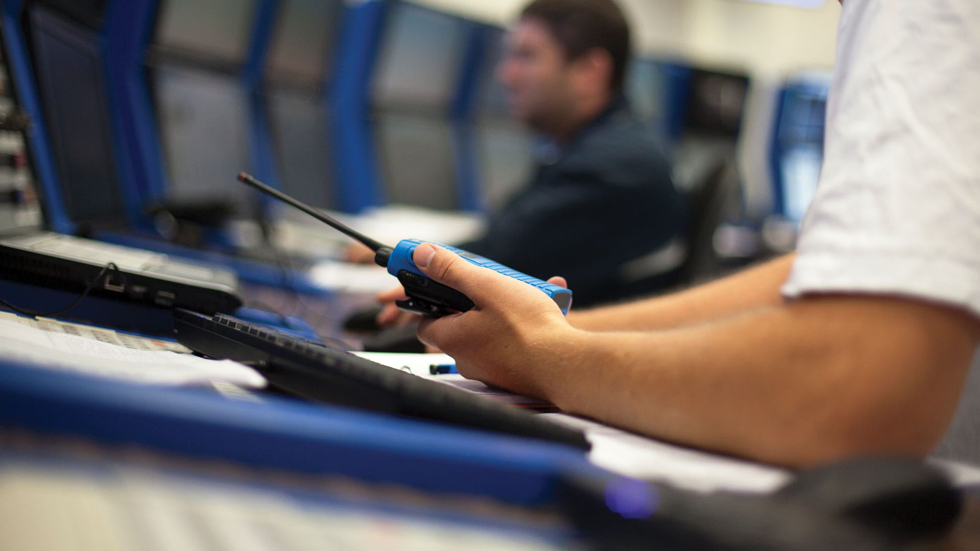 a man holding a communications radio in an office