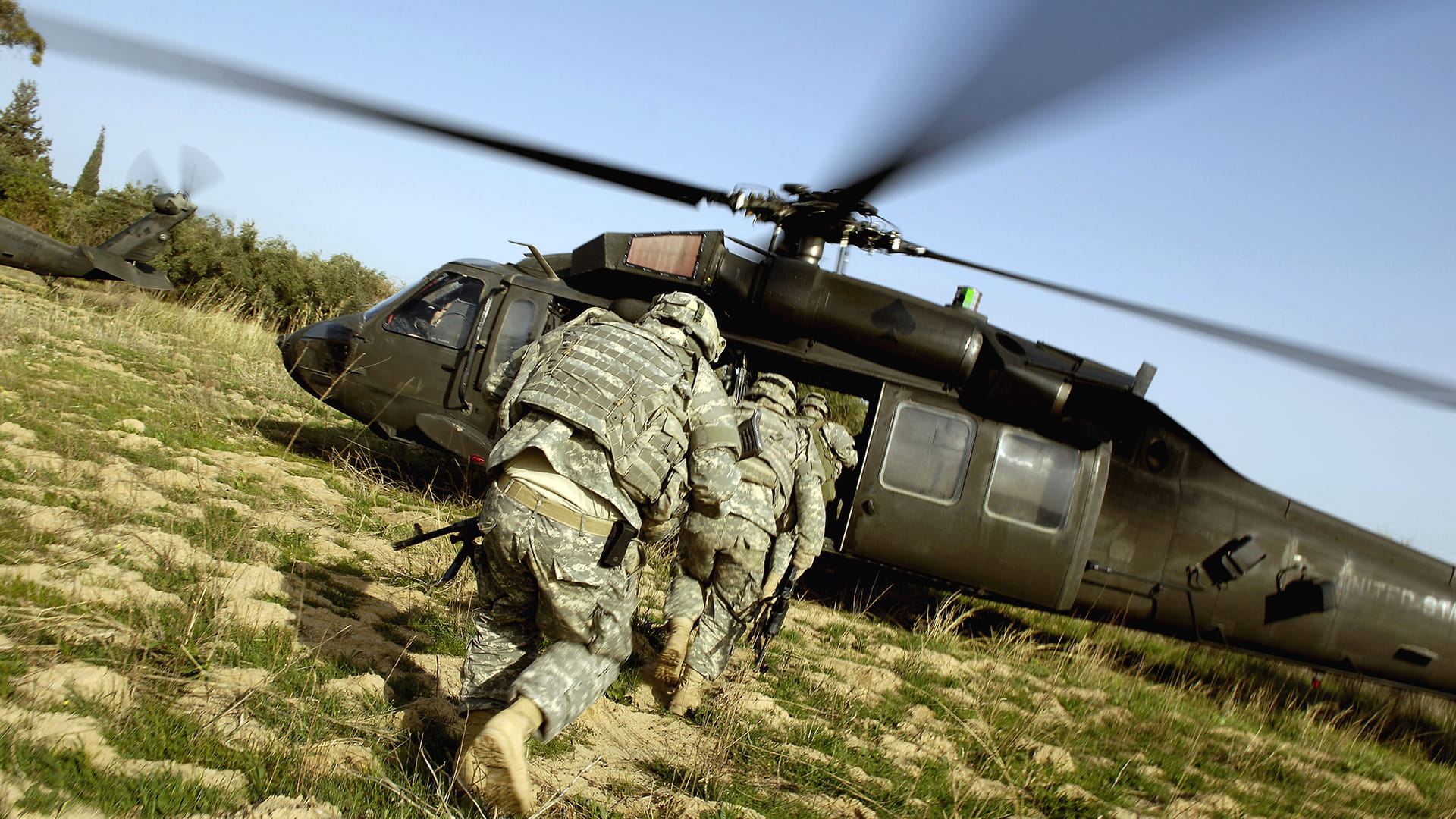 Soldiers running toward a helicopter